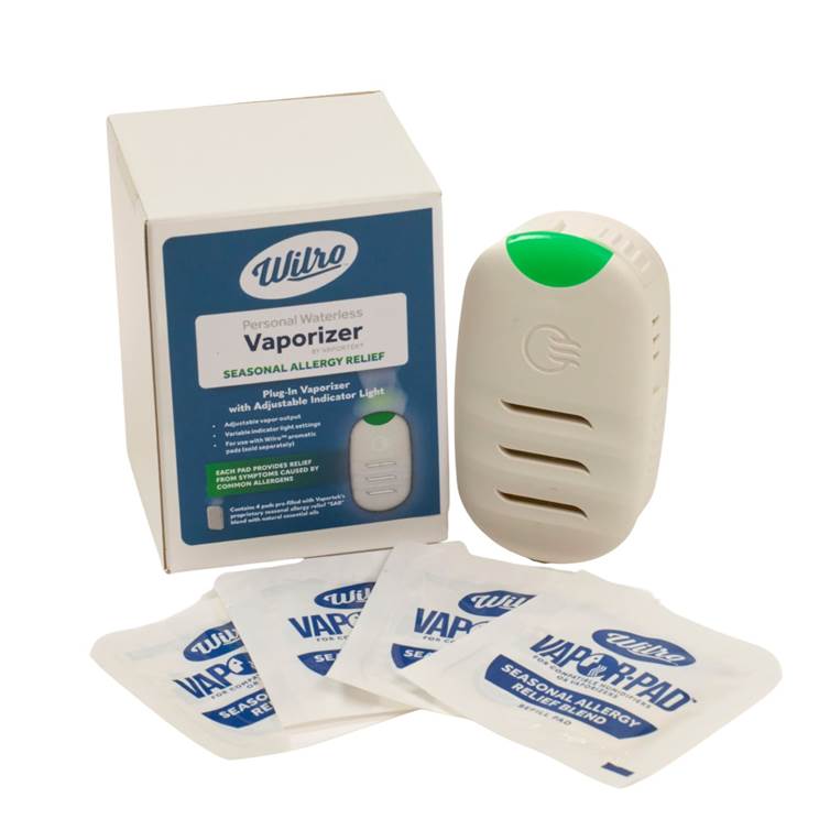 A Wilpro personal waterless vaporizer with a green indicator, shown alongside its box and four individually packaged vapor pads, all labeled for seasonal allergy relief.